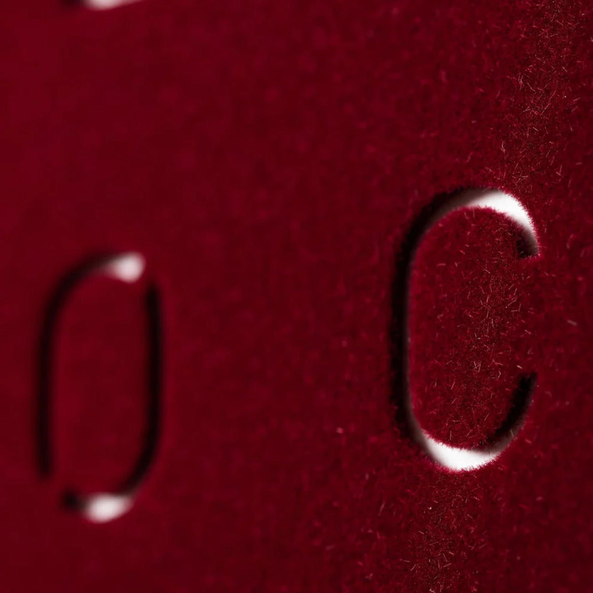 Red velvet wall clock close-up showing raised English text letters