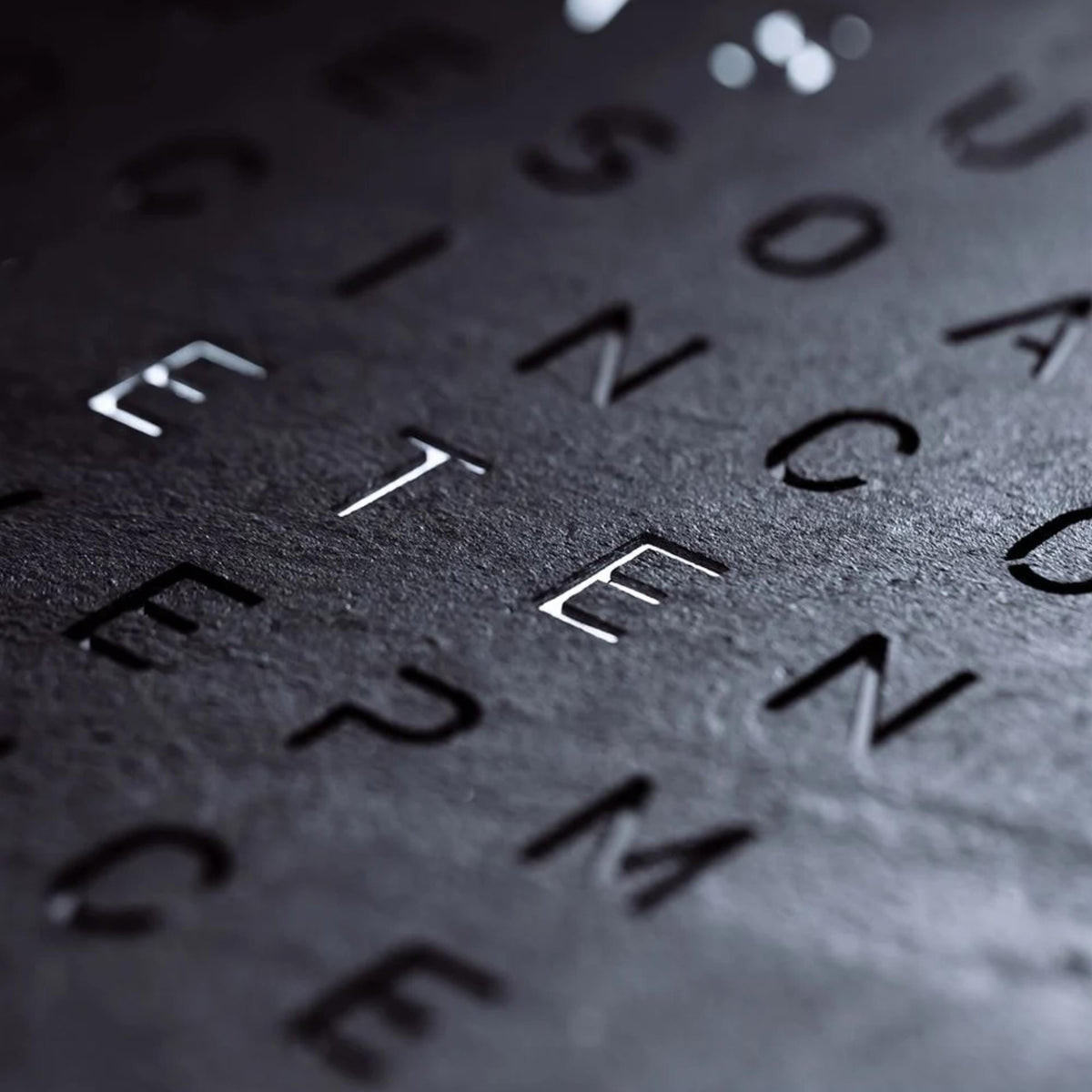Close-up of letter and numeral markers on dark slate wall clock face