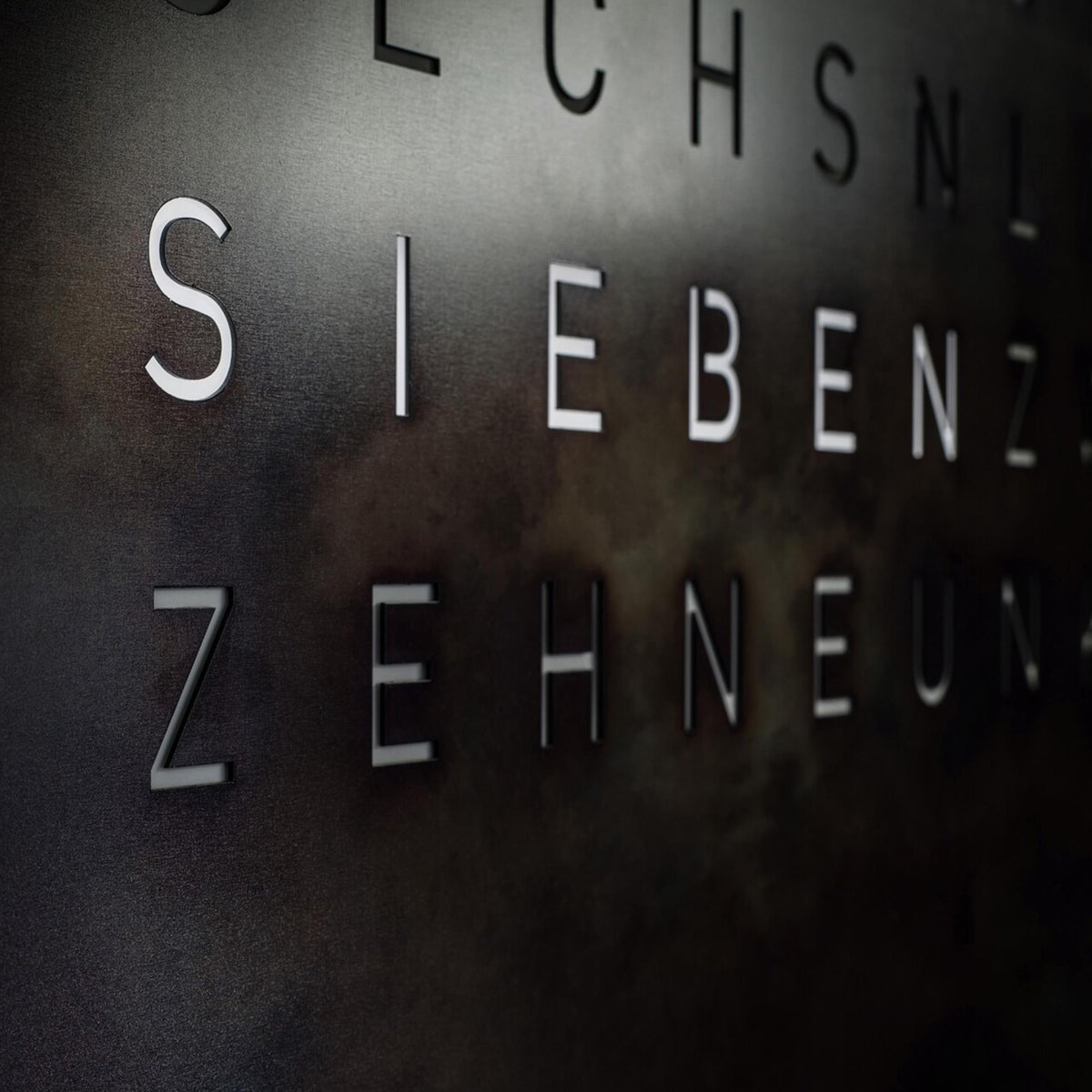 Close-up of raw iron English word dial with glowing time letters