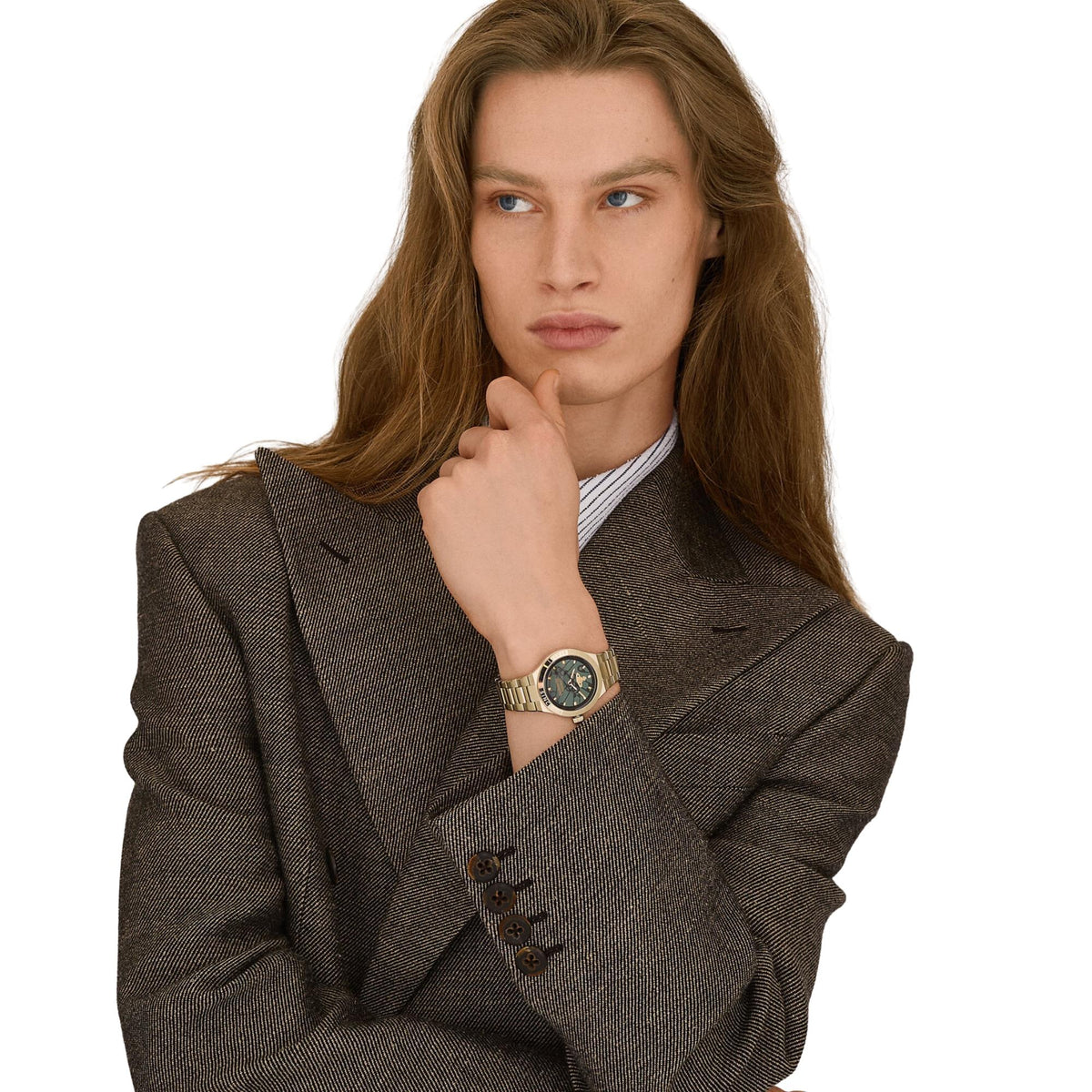 Gold-tone watch worn on wrist with dark green dial and stainless steel link bracelet