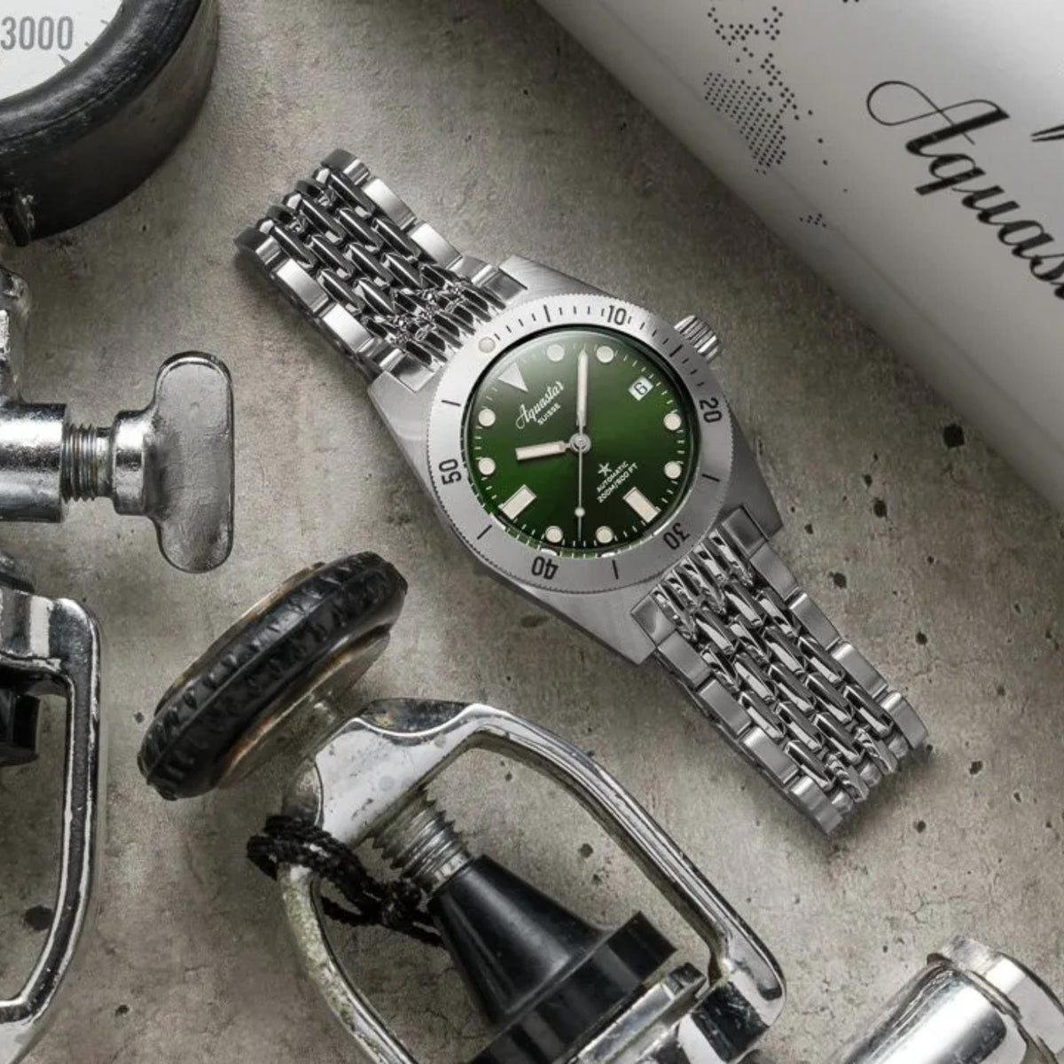 Men's automatic dive watch with green dial and silver steel case on metal bracelet.