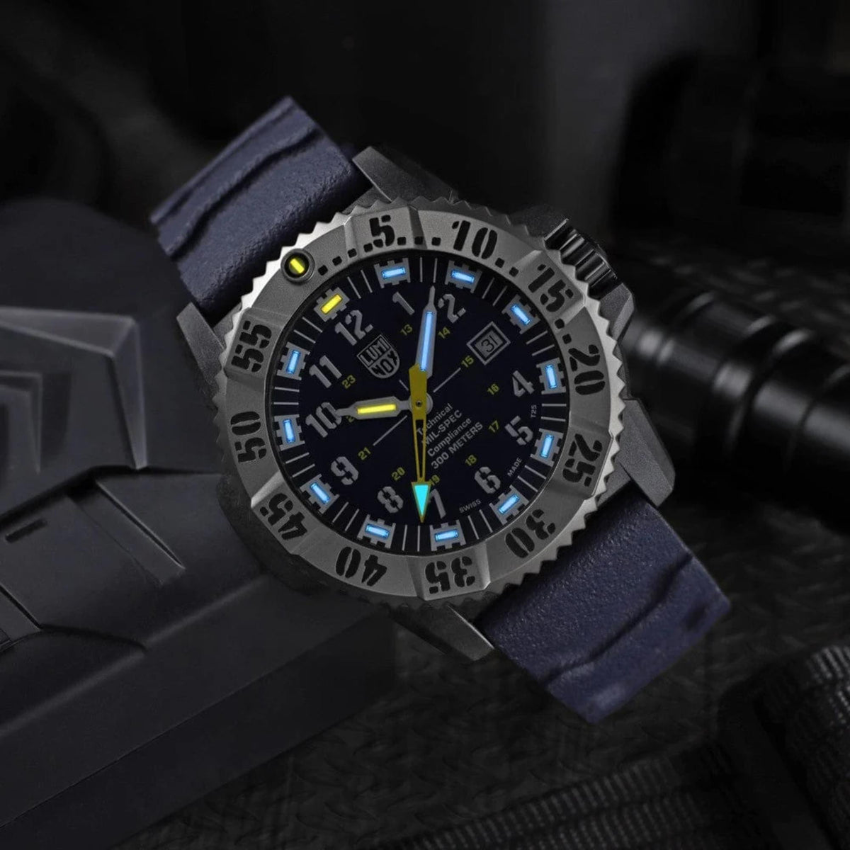 Men's quartz dive watch angled view with blue dial, rugged silver bezel, navy rubber strap.