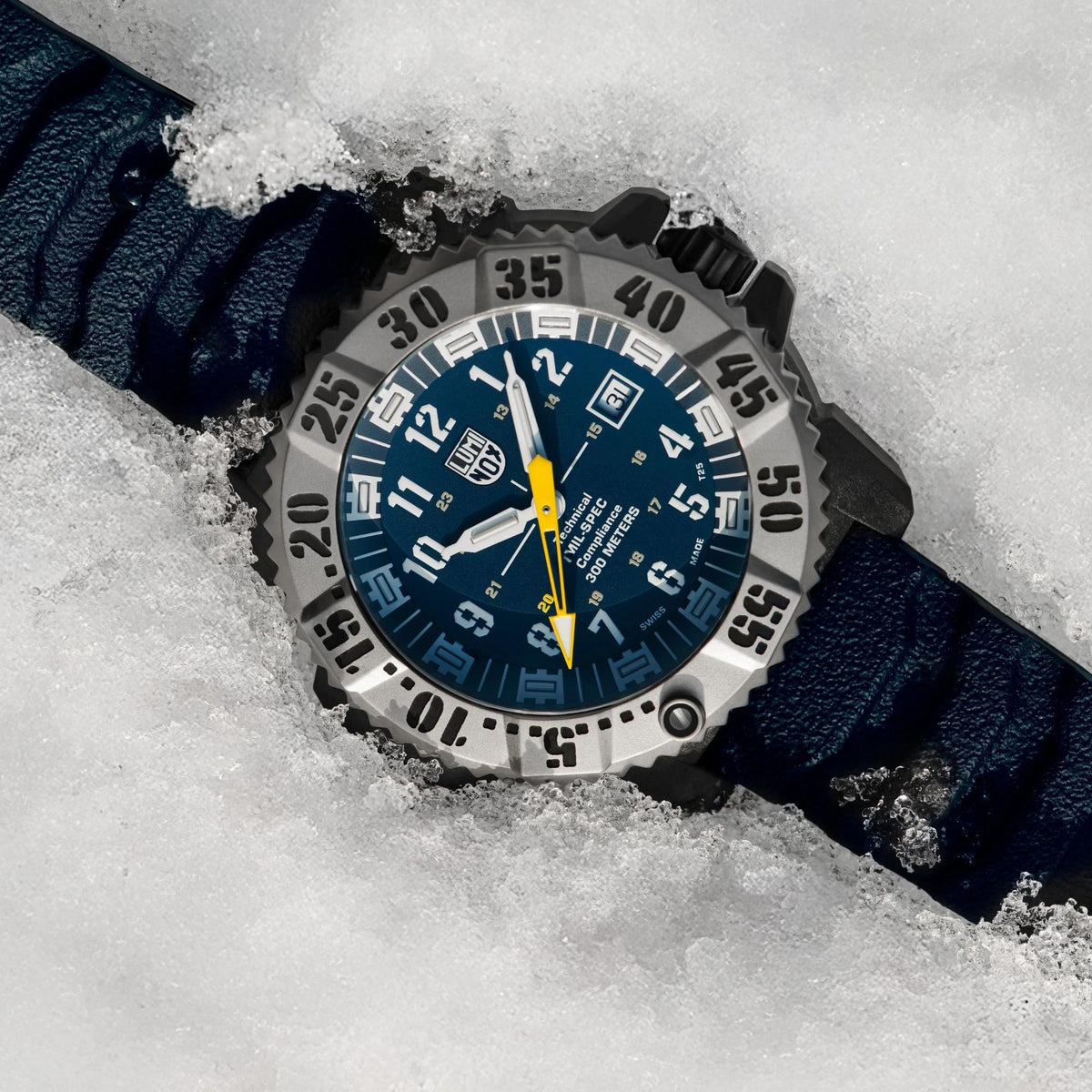 Men's quartz dive watch in snow with blue dial and dark navy rubber strap.