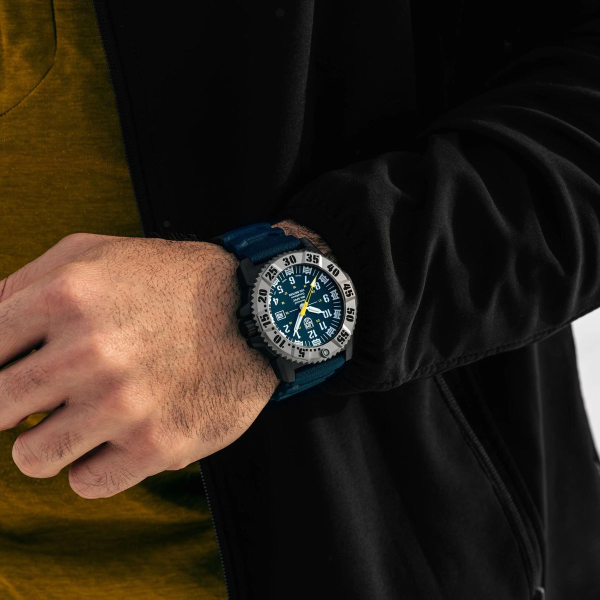 Men's quartz dive watch worn on wrist with blue dial and dark navy rubber strap.