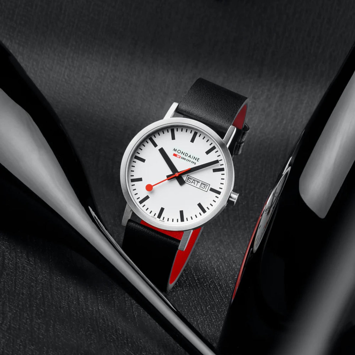 Mondaine Classic A667.30360.11SBBV minimalist timepiece showcased in a dark setting between two glass bottles