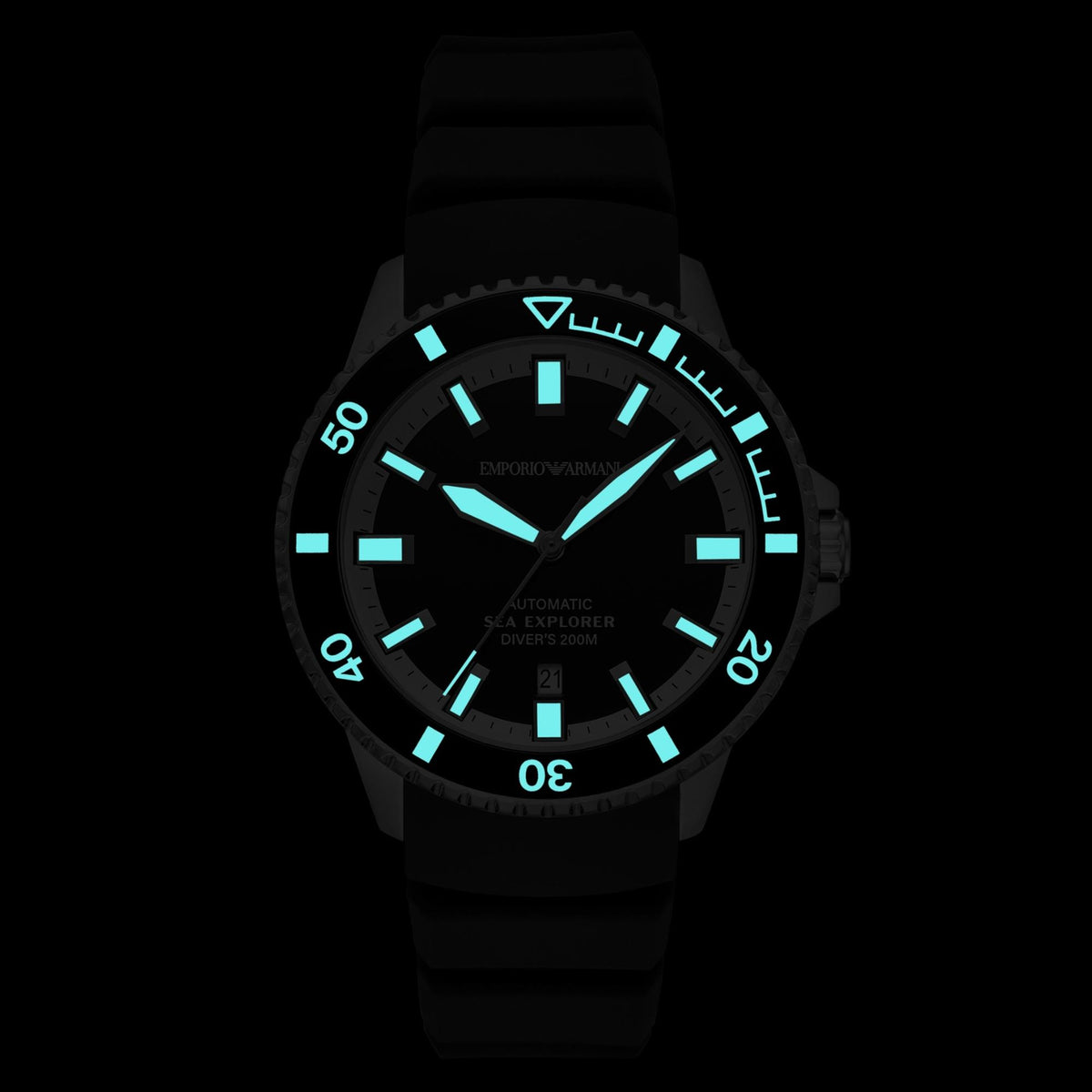 Darkened view of the Emporio Armani Sea Explorer AR60086 dive watch highlighting the glowing aqua-blue lume hands, indices, and bezel markings