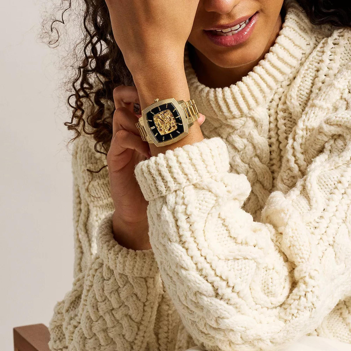 Fossil Machine x Nick Jonas LE1218 automatic watch worn on a female wrist in white cable knit sweater lifestyle setting