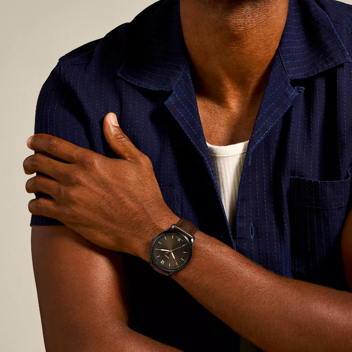 On-wrist shot of Fossil Minimalist FS5551 mens timepiece showing the black dial, dark casing, and brown leather strap