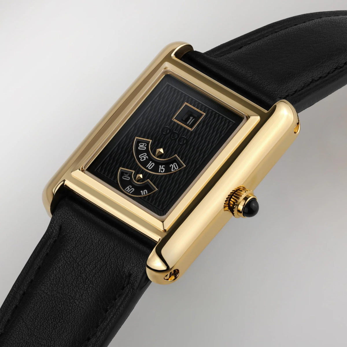 Automatic wristwatch angled view with gold case and black dial; black leather strap