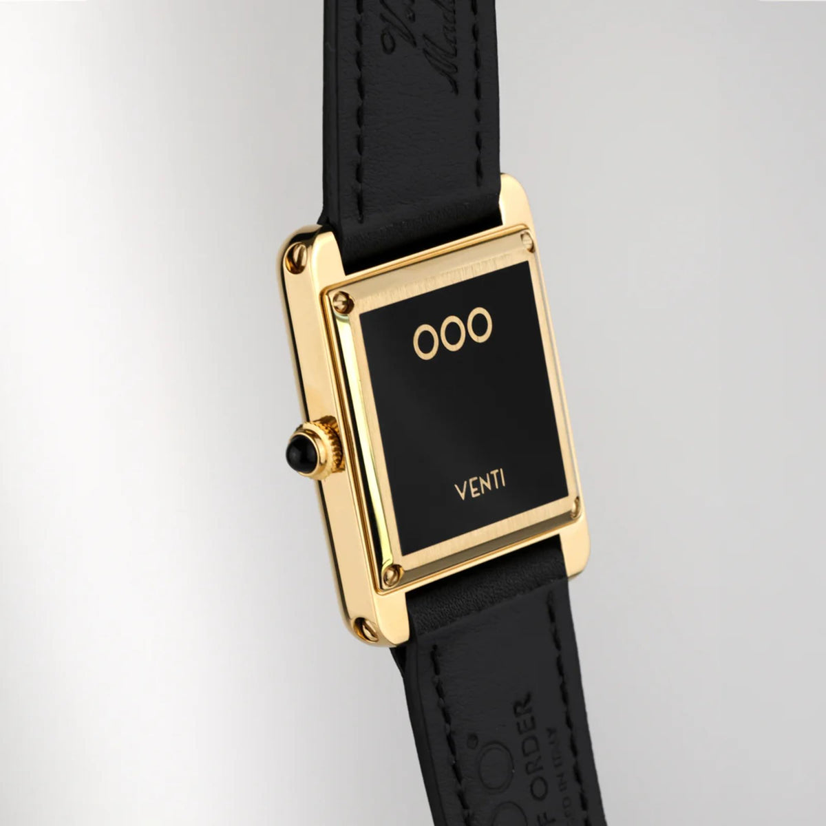 Automatic wristwatch side view: gold rectangular case, black dial, black leather strap