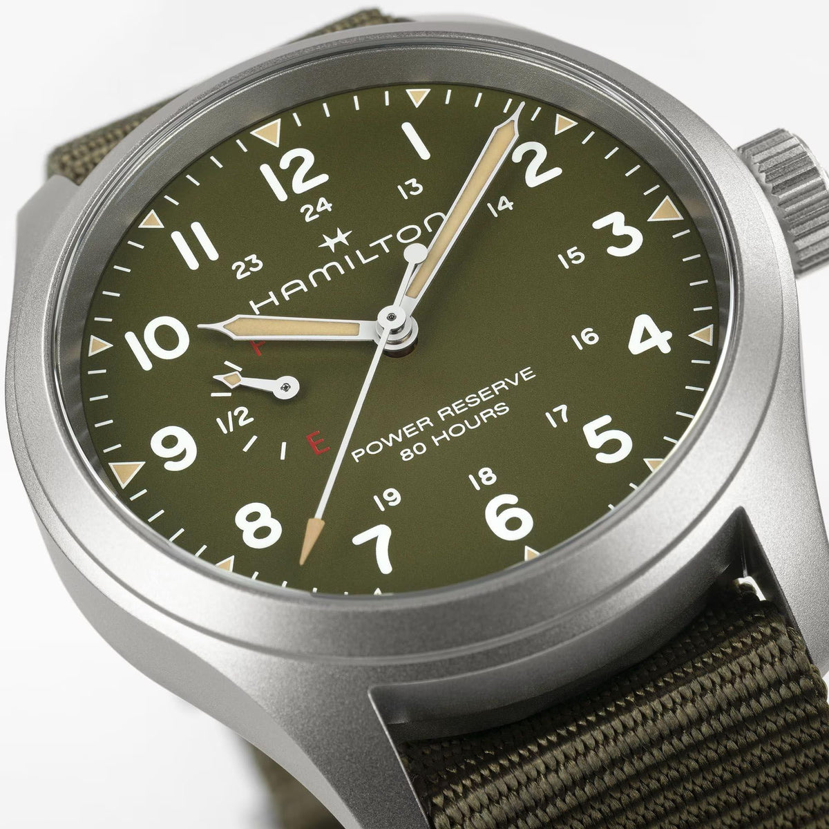 Men's manual-wind watch close-up: green dial with white numerals and power reserve