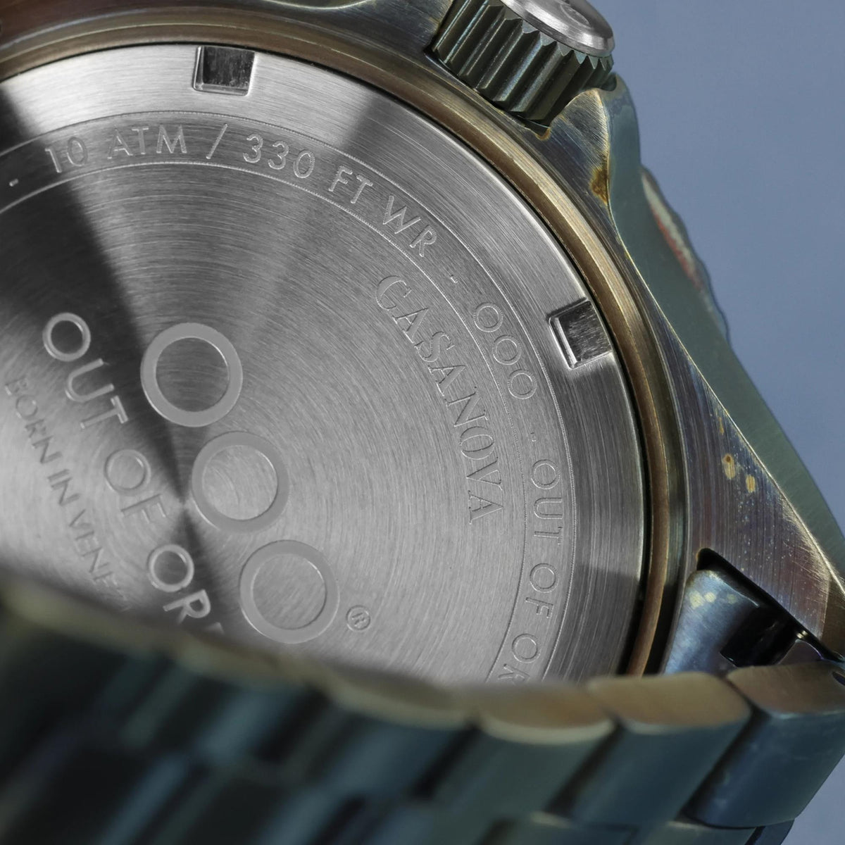 Men's quartz watch caseback with 10 ATM / 330 FT WR text and OOO mark