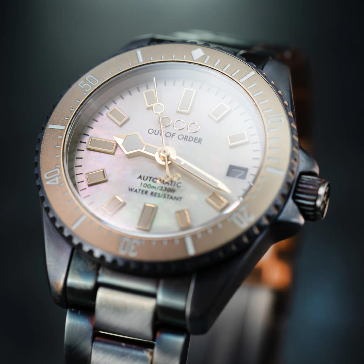 Men's automatic wristwatch close-up front view with ivory dial and steel bezel