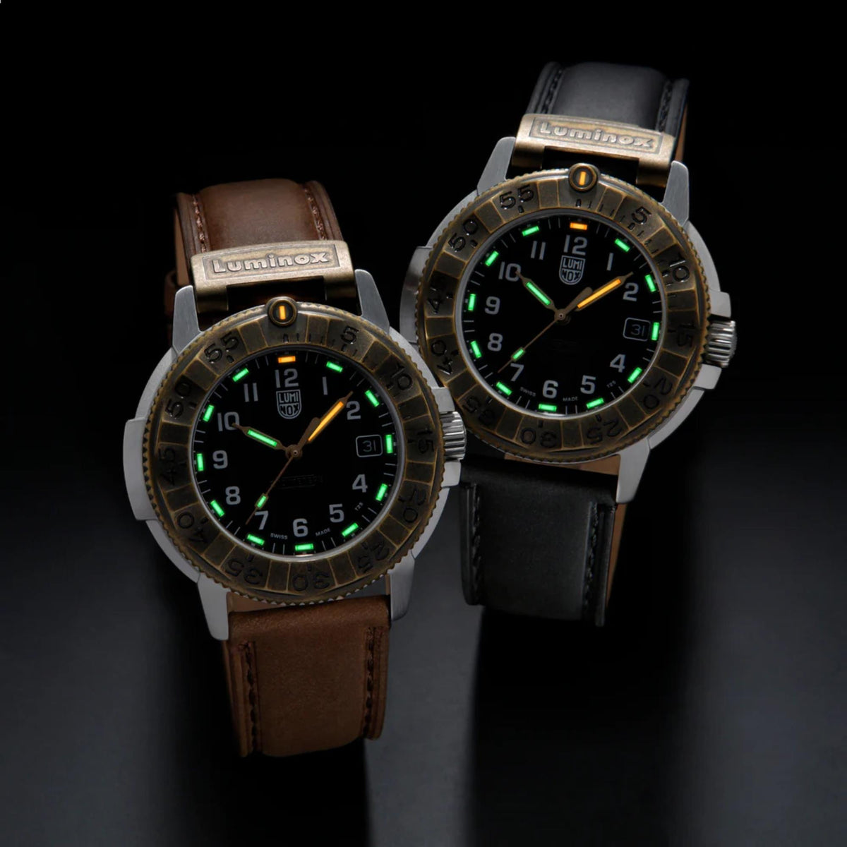 Two models of the Luminox Adventure Watch side-by-side, showing the glowing micro gas tubes of the brown leather strap version and the black leather strap version