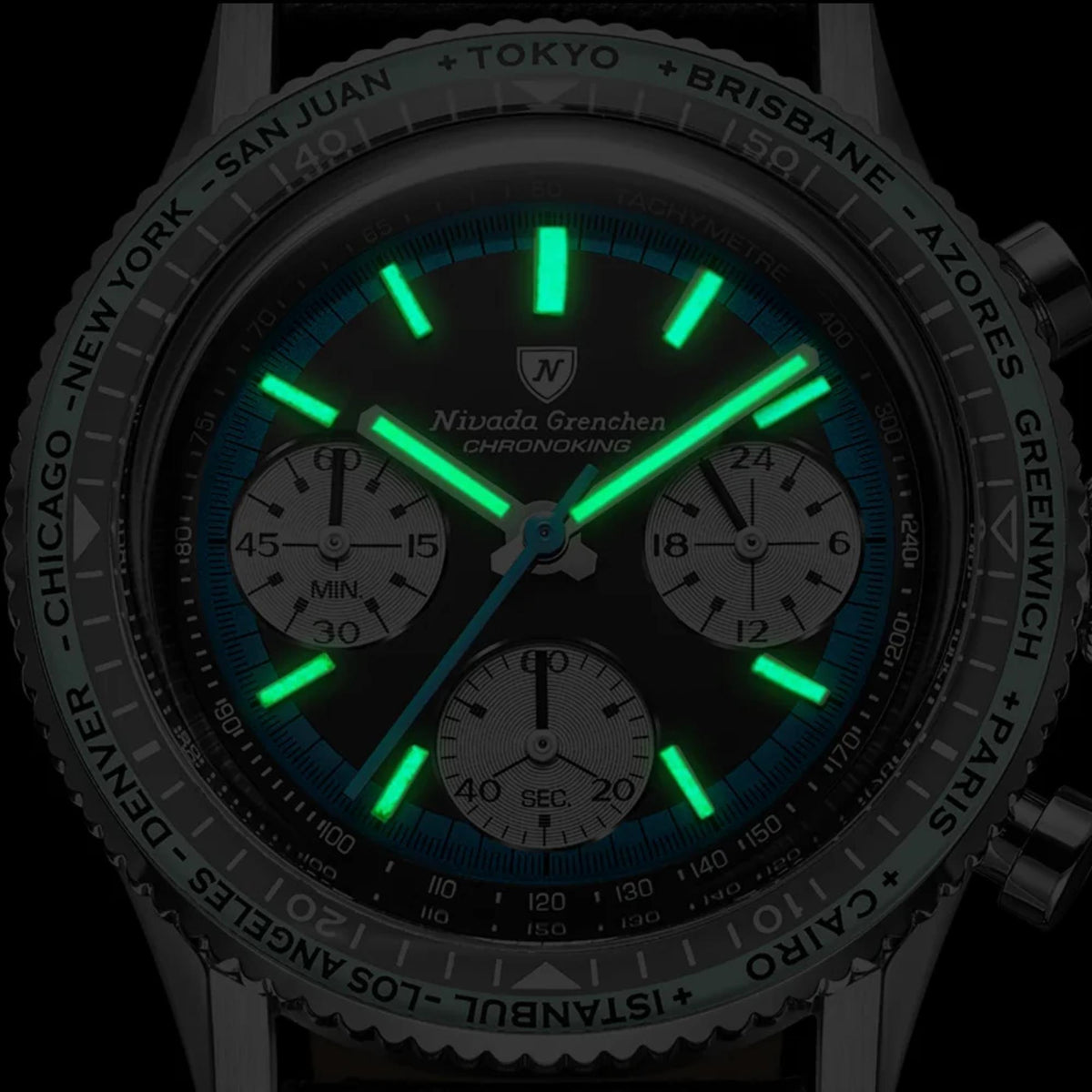 Close-up of Nivada Grenchen Chronoking dial in the dark, showing the hour markers and hands glowing in bright green Super-LumiNova