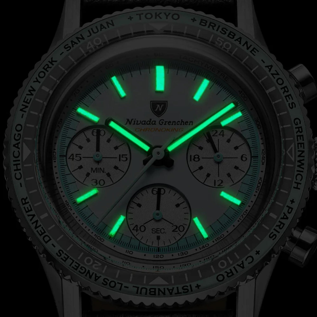 Close-up of Nivada Grenchen Chronoking meca-quartz watch 87056Q04 at night mode, showing a dark gray bezel with world city markings