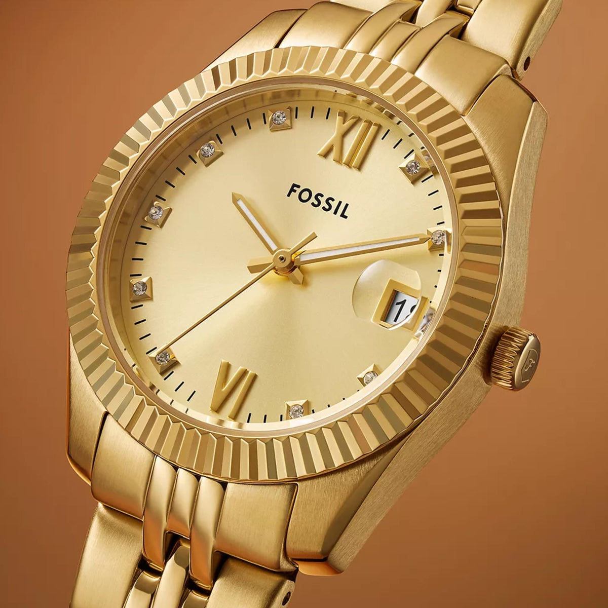 Close-up detail shot of the Fossil Scarlette ES5338 watch focusing on the gold dial with crystal markers, date window, and fluted bezel