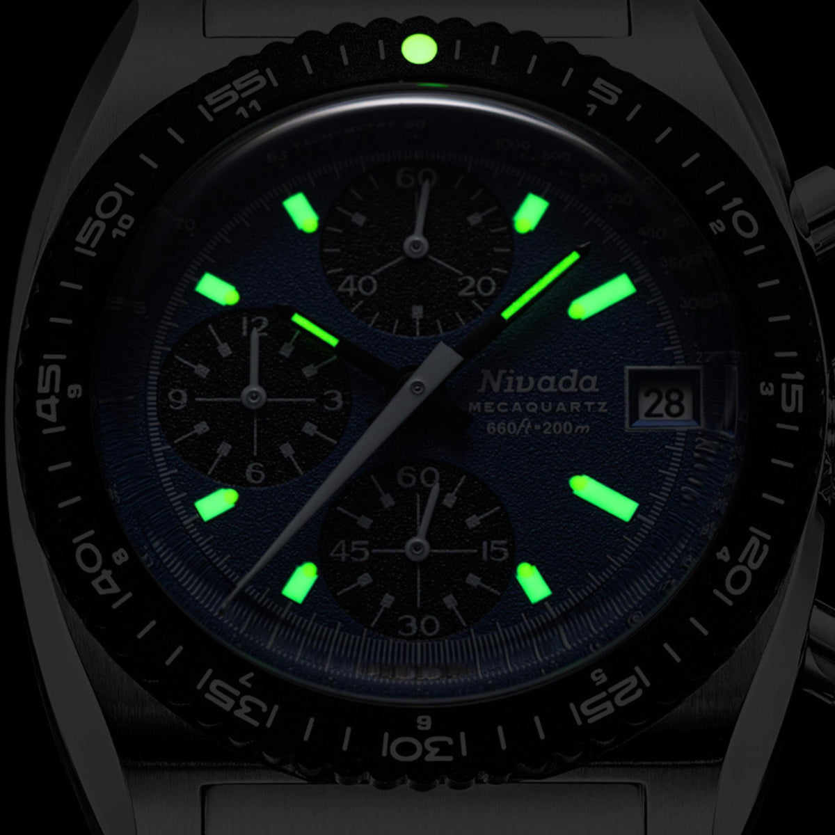 Nivada Grenchen Autochron Mecaquartz 77005Q10 mens chronograph watch showing green luminous hands and hour markers in dark lighting