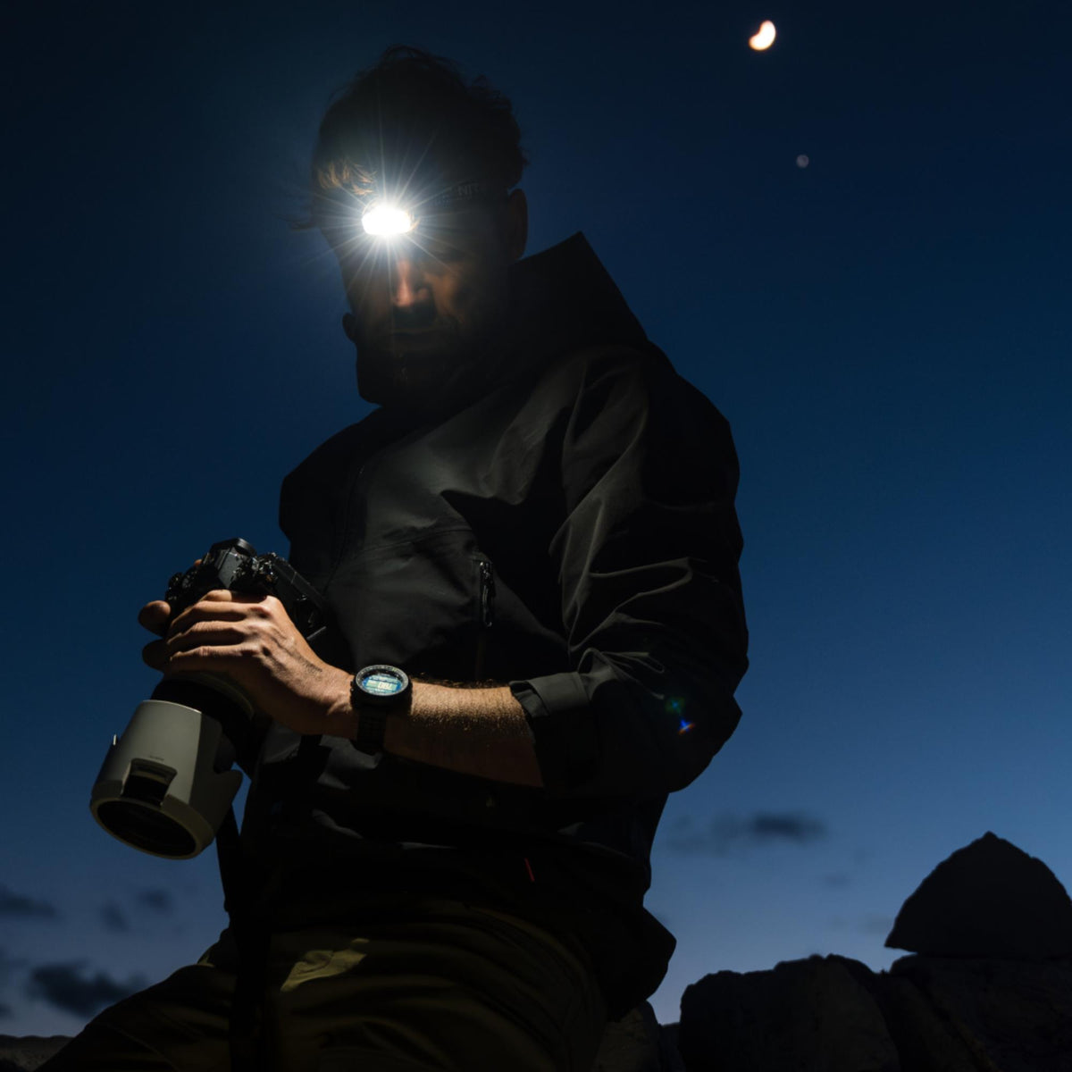 Black digital watch on wrist with illuminated face, silicone strap visible