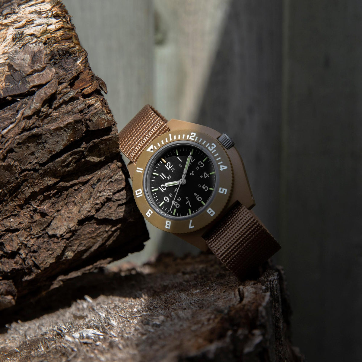 Marathon Navigator WW194001DT-0802 mens military style watch with black dial and tan nylon strap displayed on rustic wood surface