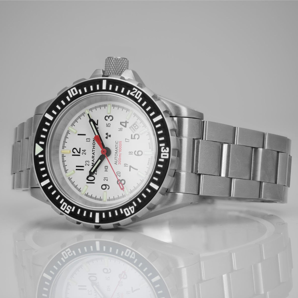 Marathon GSAR Arctic Edition WW194006SS-0513 mens automatic watch resting on a reflective surface with white dial and stainless steel bracelet