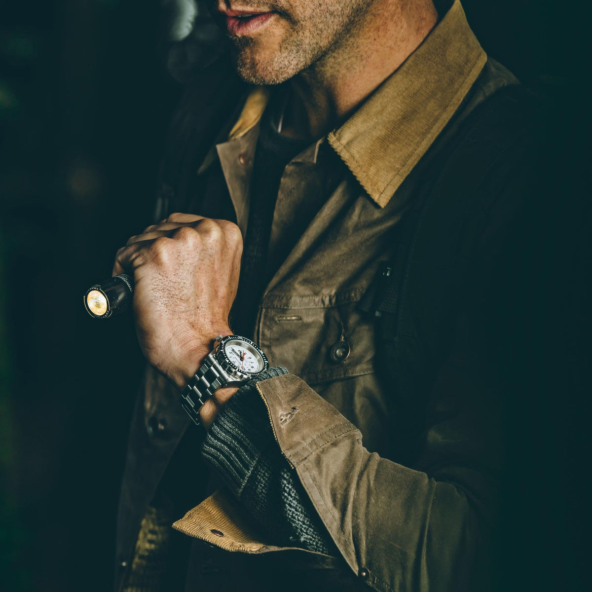 Marathon GSAR Arctic Edition WW194006SS-0513 mens automatic timepiece worn by a man holding a torch outdoors