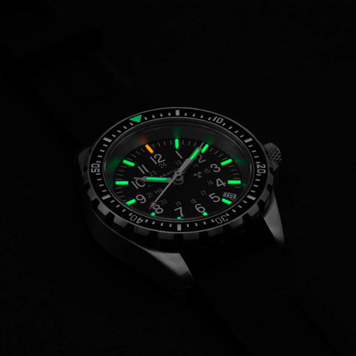 Marathon MSAR WW194027SS-0130 quartz watch showing glowing tritium gas tubes on black dial in dark conditions