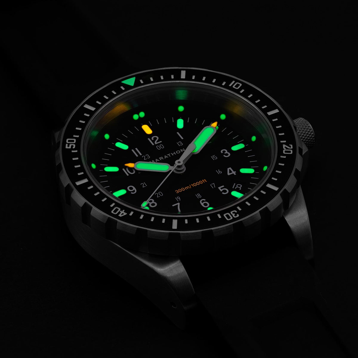 Marathon JSAR WW194018SS-0130 watch showing glowing illuminated markers and hands on black dial in dark setting
