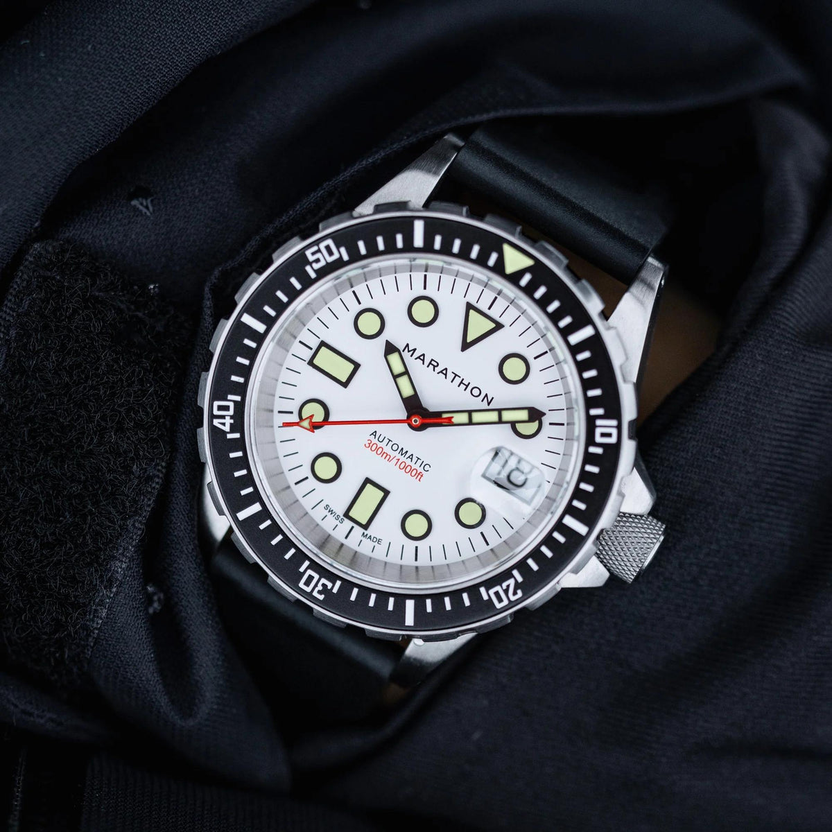Marathon OSAR-D Arctic Original Mens Automatic Watch WW194006SS-2530 resting flat on dark textured jacket material