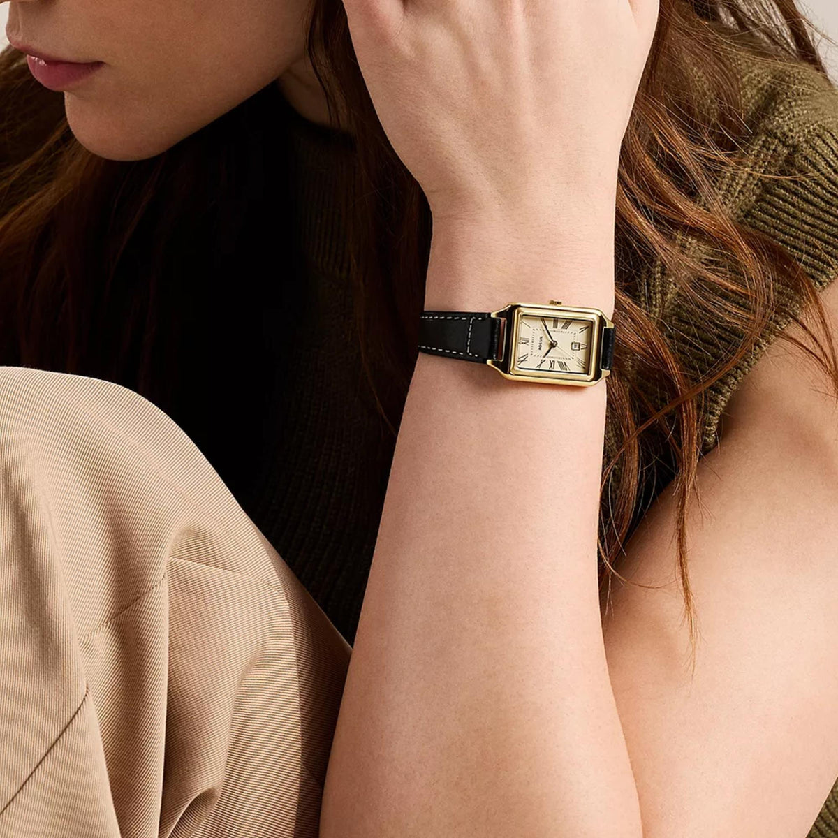 Fossil Raquel ES5505 mens watch on wrist showcasing cream dial, gold-tone case, and black leather strap