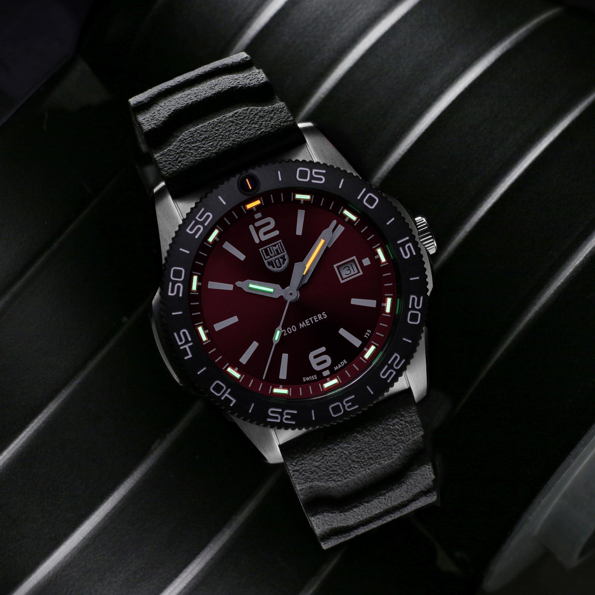 Luminox Pacific Diver 3120 Series XS.3135 mens watch angled view displaying red dial and black rubber strap on dark background