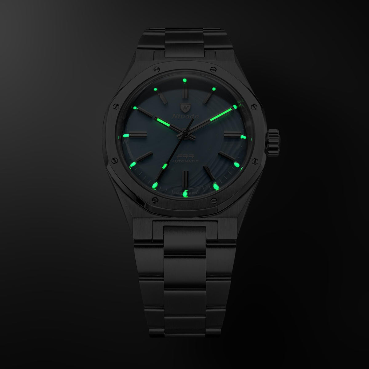 Nivada Grenchen F77 MK2 68061A77 front view showcasing luminous dial hands and hour markers in dark lighting