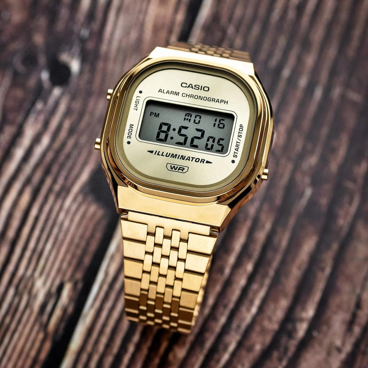 Casio Vintage A140WEG-9AEF angled view resting on wooden surface showcasing digital display and case detail