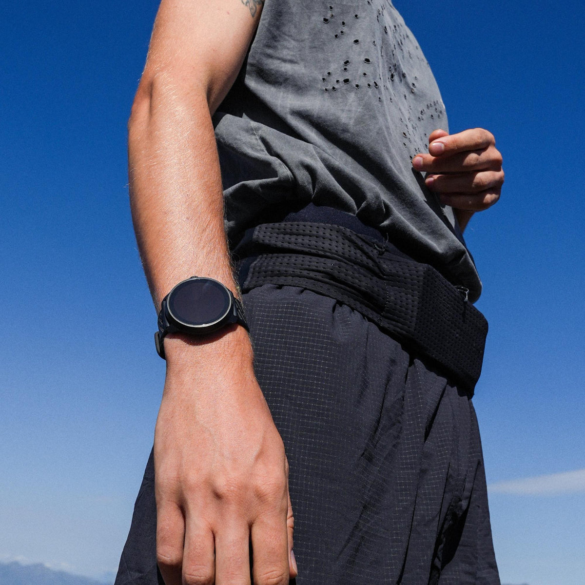 Suunto Race 3S SS051645000 lifestyle wrist shot displaying black digital smartwatch during outdoor workout