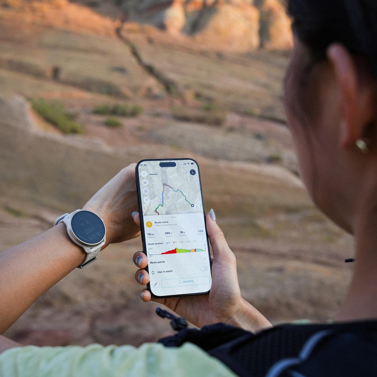 Suunto Race 3S SS051647000 lifestyle view displaying smartphone route planning screen with smartwatch worn on wrist