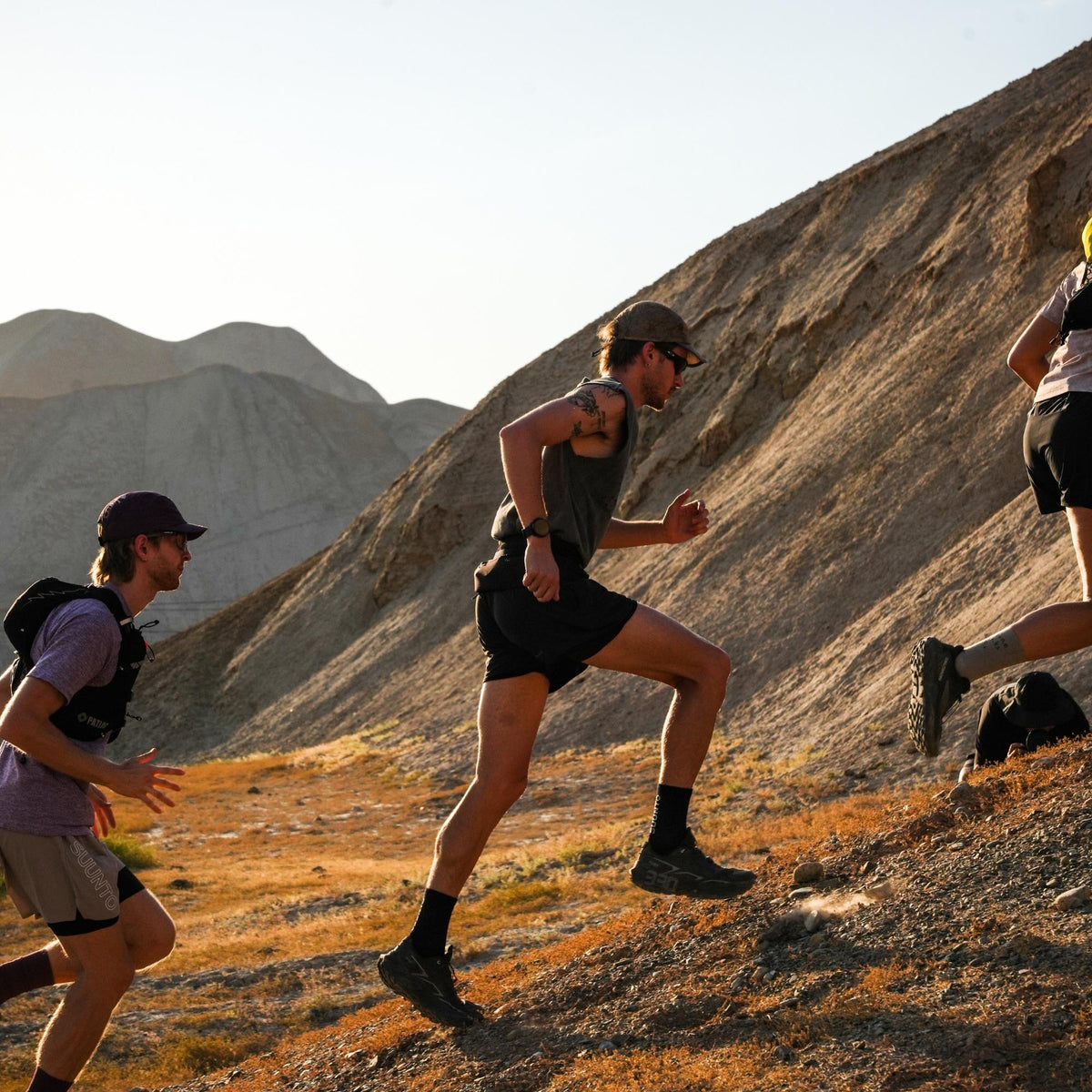 Suunto Race 3S SS051647000 lifestyle shot showing athletes running up a steep mountain incline