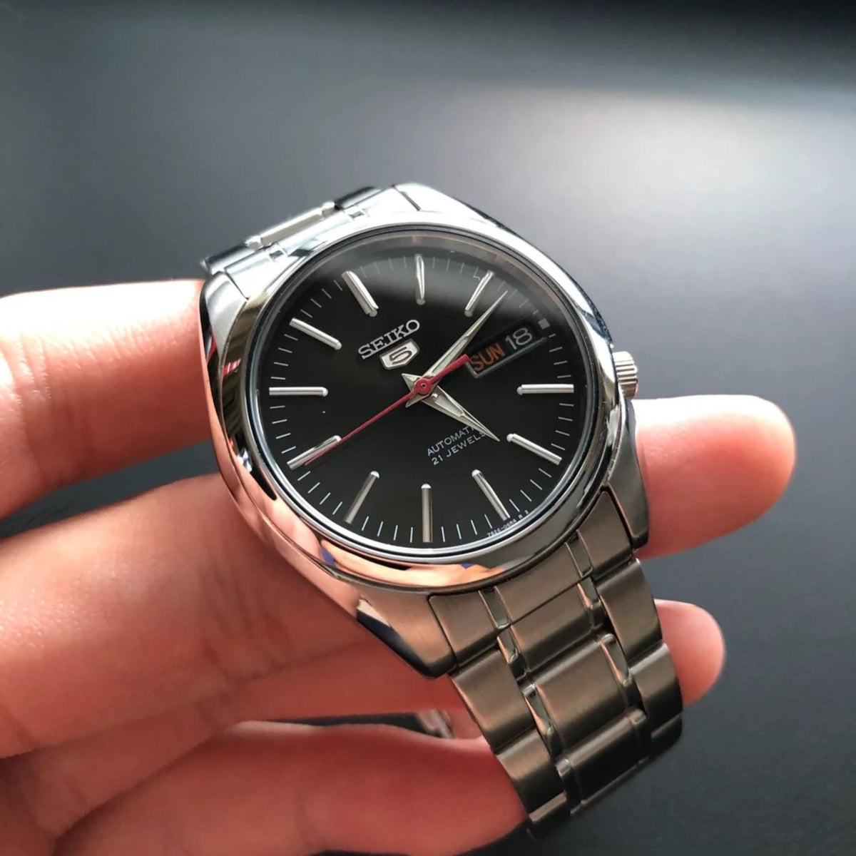Seiko 5 SNKL45K1 black dial and stainless steel watch on hand
