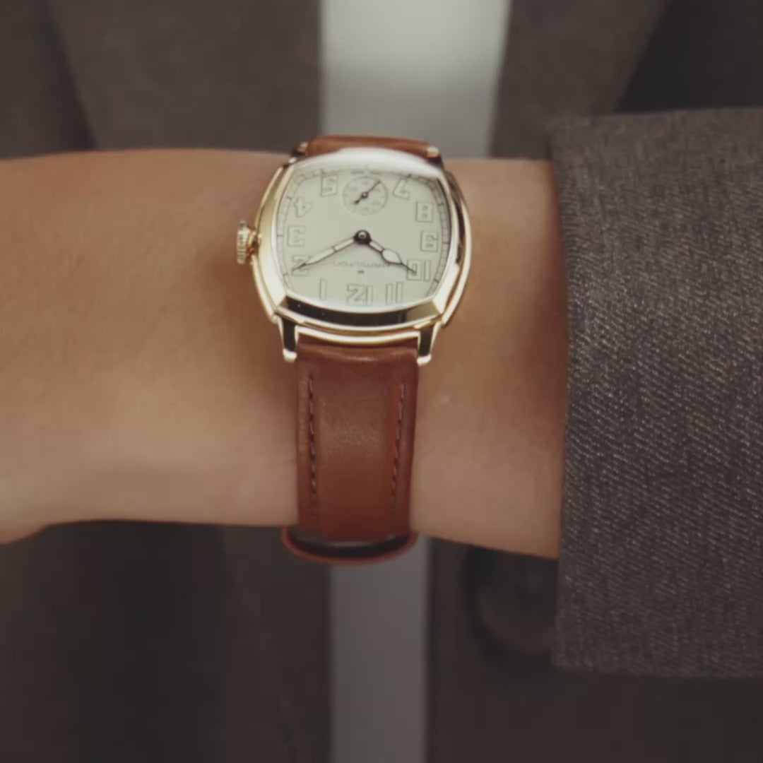 Hamilton American Classic Cushion Mechanical H36119520 close-up wrist view showing beige dial with yellow gold-tone steel case