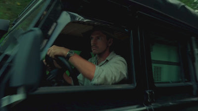 Man wearing a Luminox outdoor watch driving an off-road vehicle through the wilderness