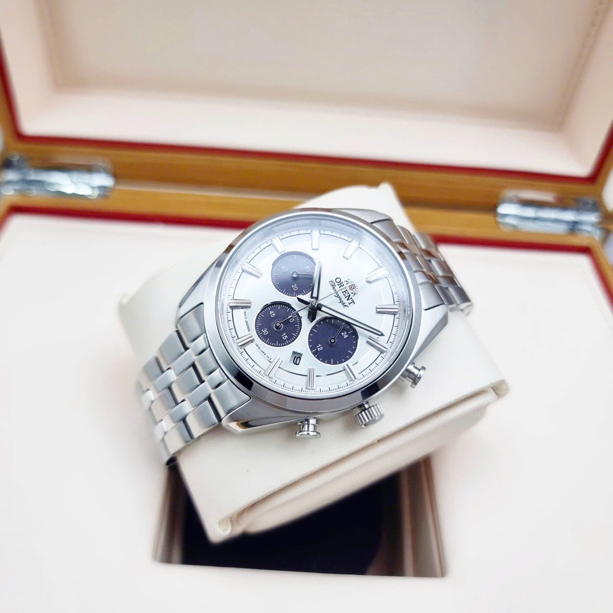 Men’s solar chronograph watch with white dial and steel bracelet, shown on a box