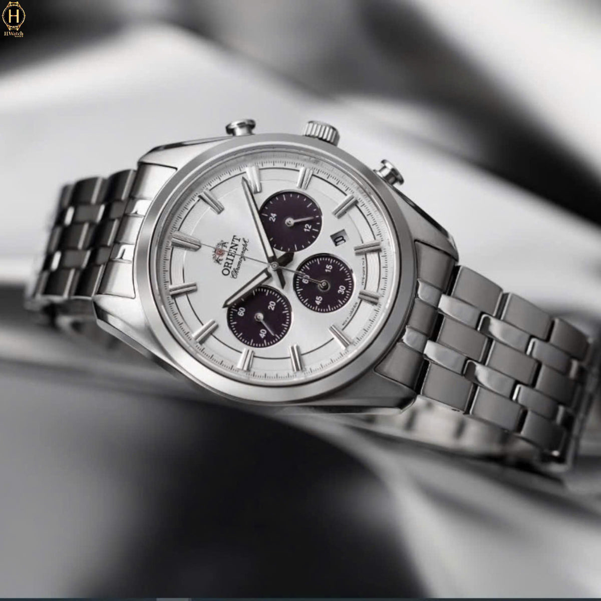 Men’s solar chronograph watch with white dial and steel bracelet, angled close-up