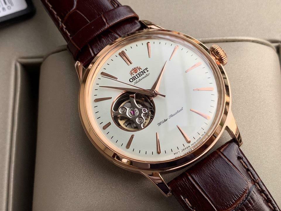 Rose gold automatic open-heart watch on brown leather strap, white dial