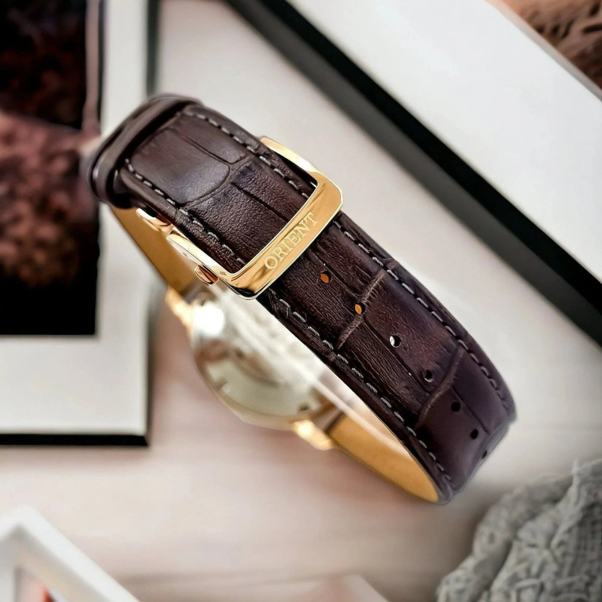 Orient Bambino Sun and Moon RA-AK0009T30B brown leather watch strap with gold-tone buckle and stitched detail
