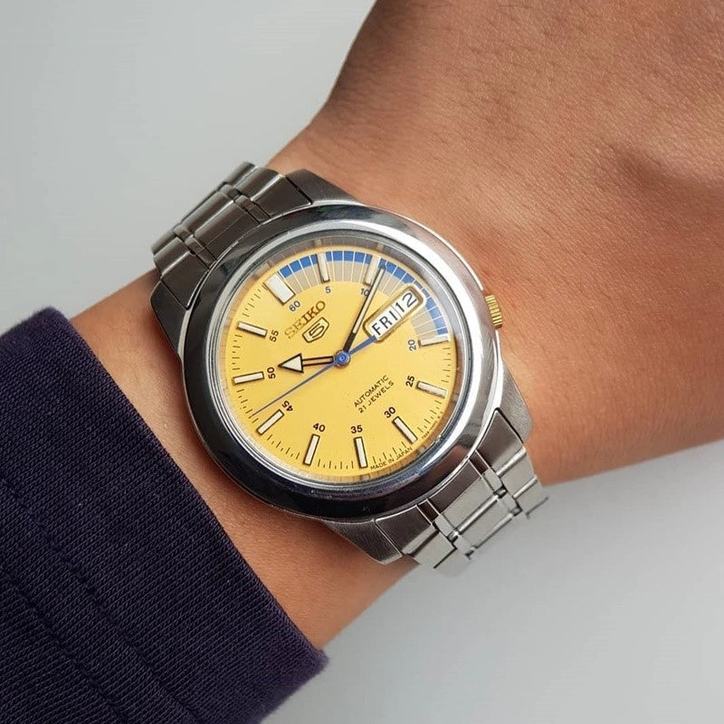 Men's automatic wrist watch on wrist, gold dial and stainless steel bracelet