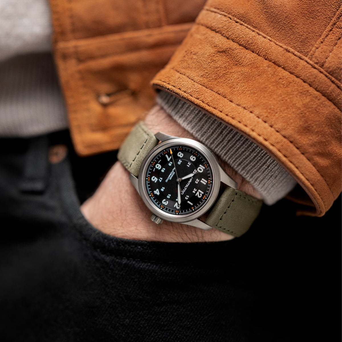 Hamilton Khaki Field H70205830 mens automatic watch lifestyle wrist shot paired with suede jacket showing black dial and green strap