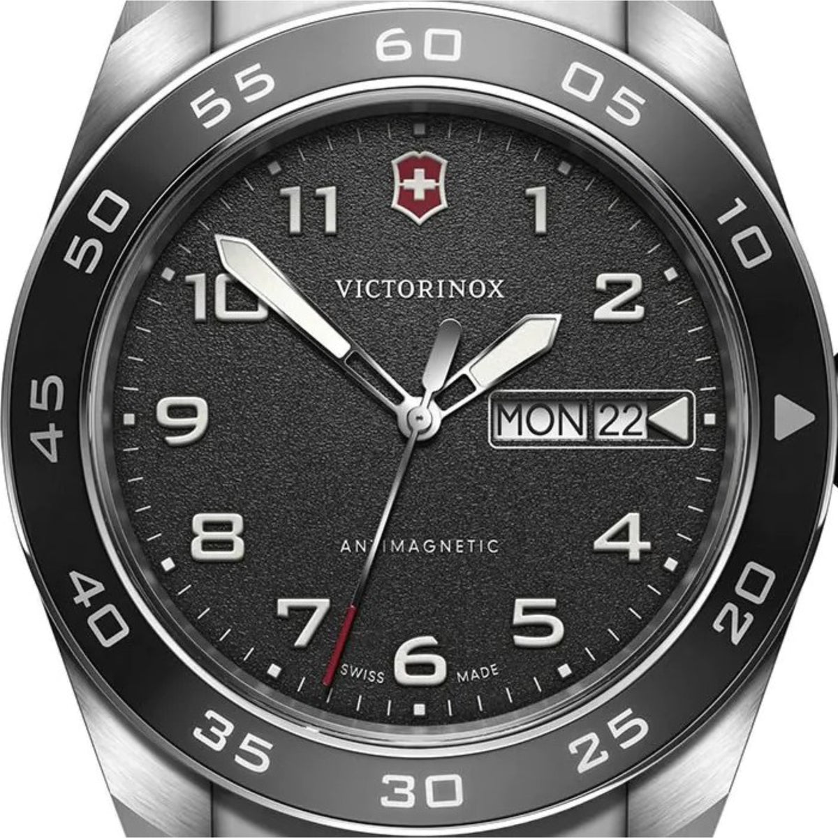 Black dial quartz watch close-up with silver hands and markers; date window shows MON 22