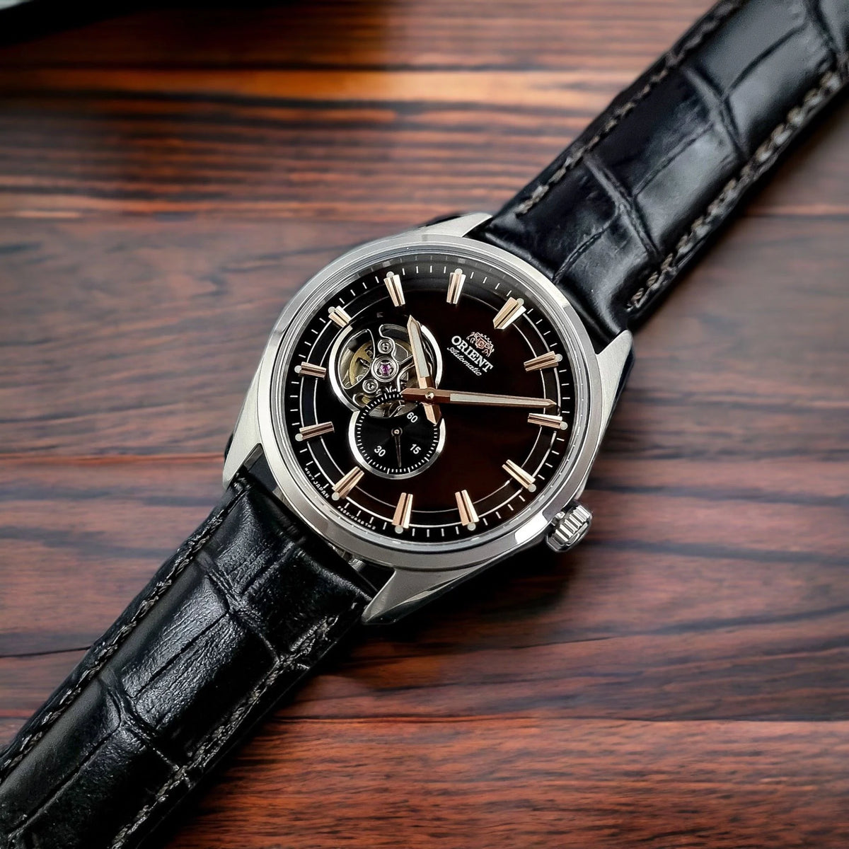 Men's automatic watch with black dial, rose-gold hands, and black leather strap