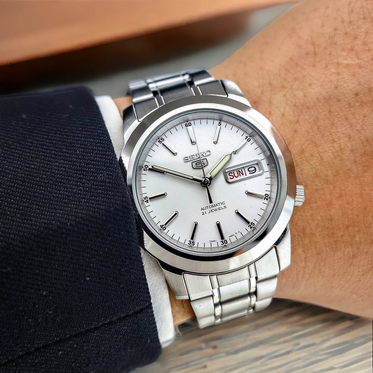 Seiko 5 Automatic SNKE49K1 wrist shot showcasing white dial with steel watch bracelet