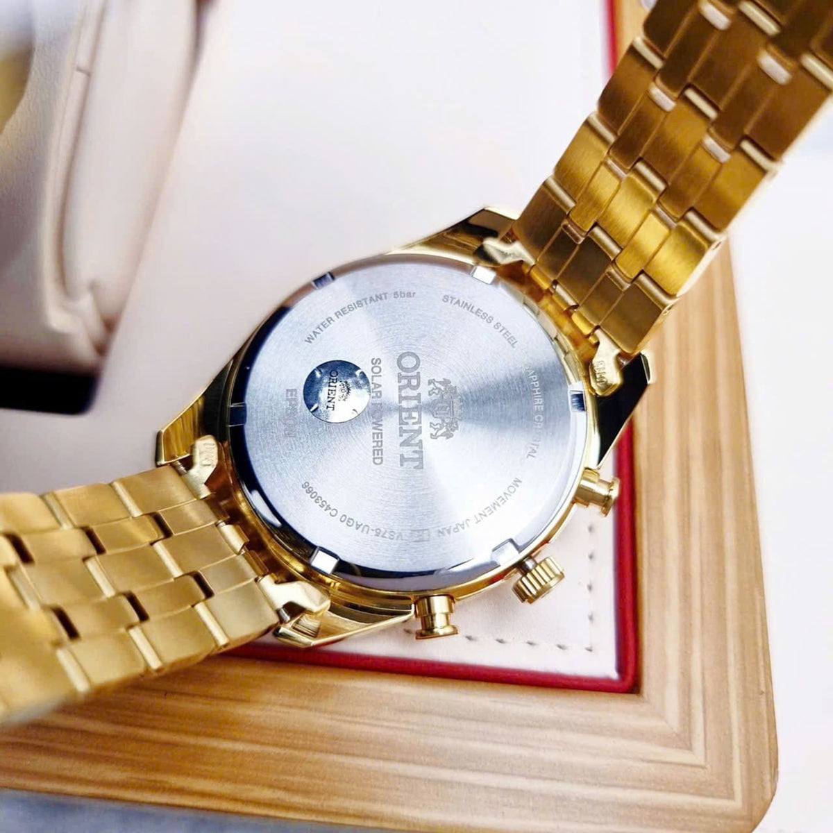 Men's solar chronograph watch with engraved caseback and gold-tone steel bracelet