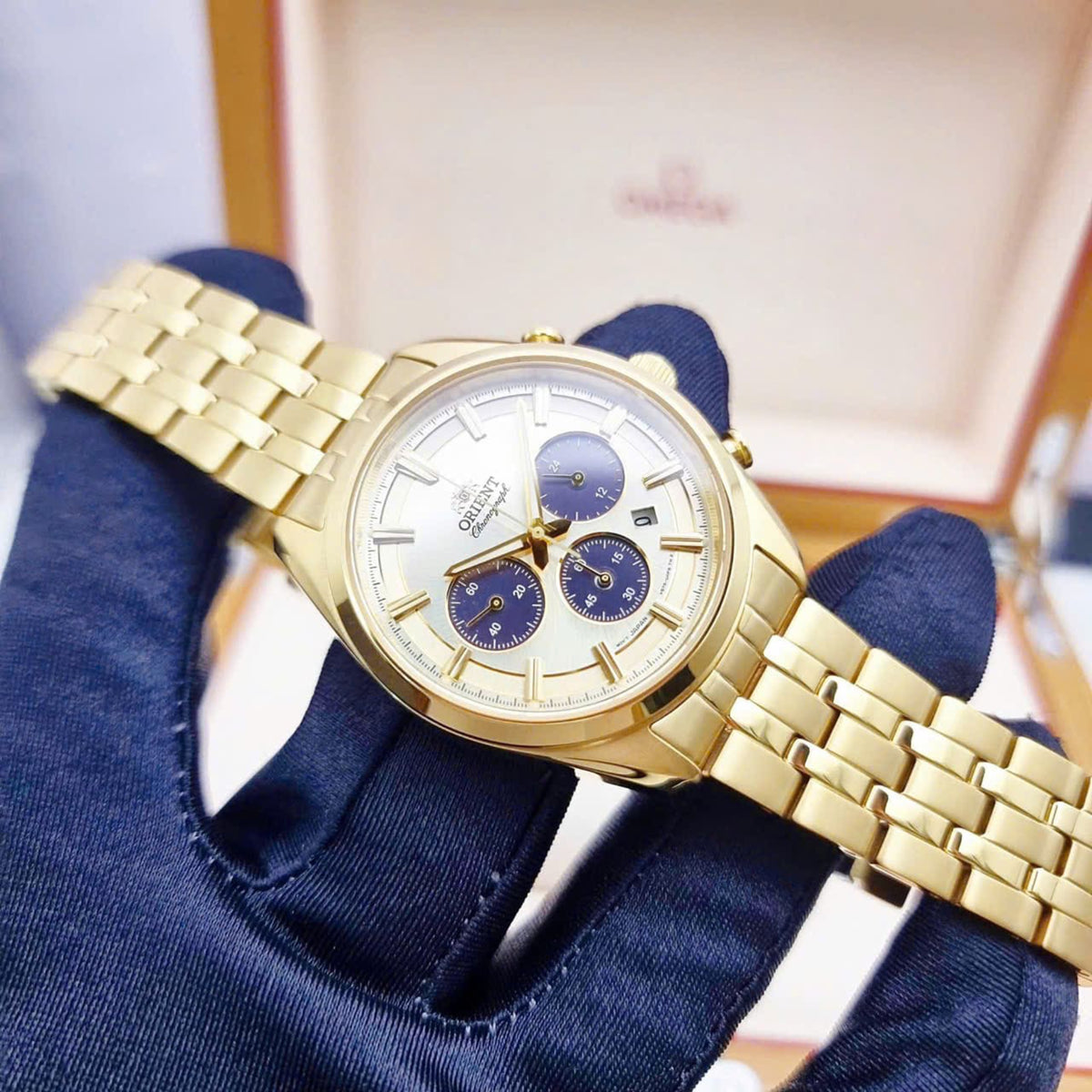 Men's solar chronograph watch with gold-tone bracelet and blue subdials on champagne dial